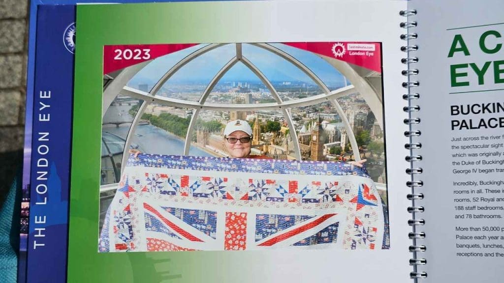Rona the Ribbiter holding her Londontowne quilt at the London Eye in England